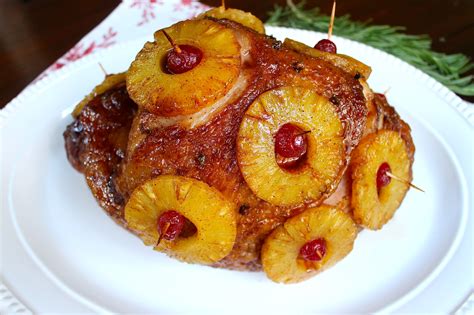 Fotografía profesional de un jamón planchado glaseado con rodajas de piña y cerezas en una bandeja festiva.