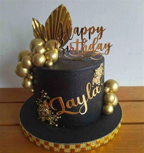Torta minimalista negro y dorado con el número 50