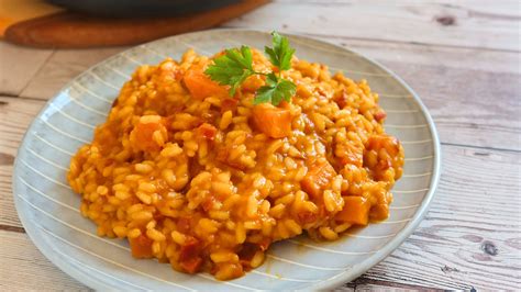 Fotografía cenital de una calabaza horneada servida como recipiente para un arroz meloso con setas y carne.