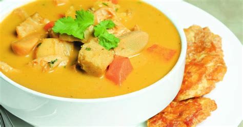 Plato de sopa de caracol hondureña servido con arroz y tajadas de plátano