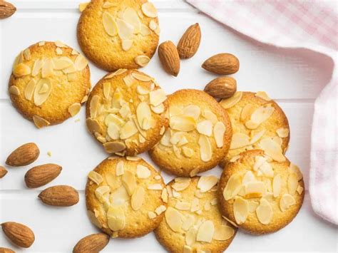 Galletas de almendras montadas sobre papel de horno con almendra entera