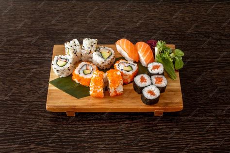 Fotografía de una bandeja de sushi artesanal con piezas variadas de nigiri y maki sobre una mesa de madera