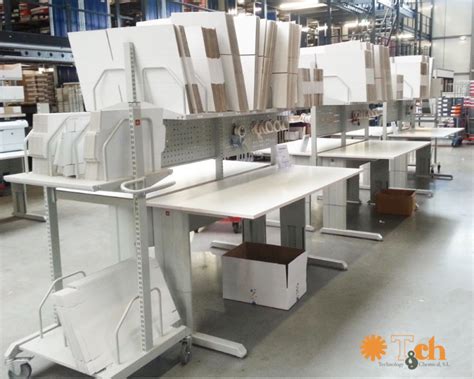 Fotografía detallada de la mesa de empaque ergonómica con soportes para bobinas plásticas