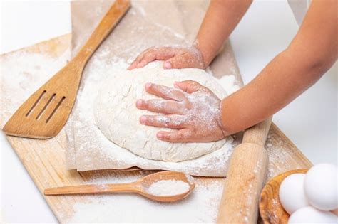 Manos de niños amasando la masa de pizza