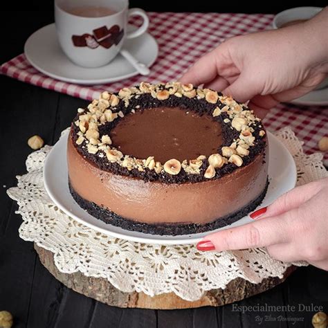 Cheesecake de Nocilla con decoración de migas de galleta y avellanas.