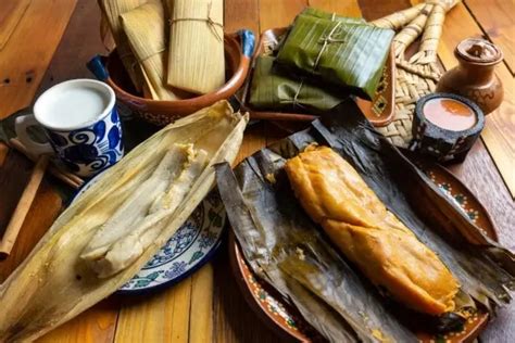 Fotografía de una mesa llena de diversos tipos de tamales mexicanos.