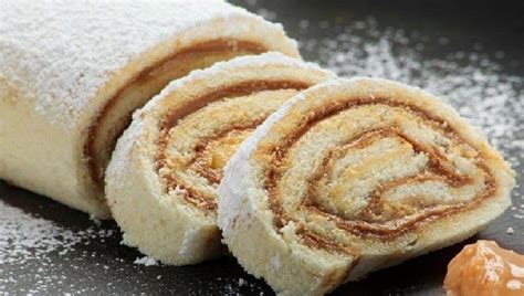 Foto de un brazo de reina chileno tradicional cortado en rebanadas, mostrando el relleno de manjar.