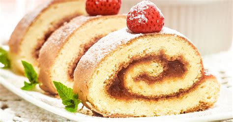 Foto de un brazo de reina con base oscura de galleta y relleno blanco, decorado.