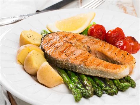 Plato de salmón fresco horneado con vegetales y hierbas aromáticas