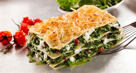 Plato de lasaña vegetal al horno con capas visibles de verduras y lentejas
