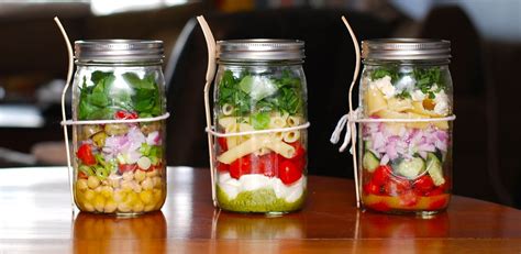 Esquema de capas para preparar ensaladas en frasco de vidrio: aderezo al fondo, verduras duras, granos, verduras suaves y proteína.