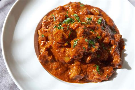 Plato de Curry de Cordero Rogan Josh con guarnición de arroz y naan.