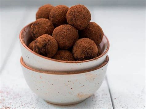 primer plano de trufas de dátil y cacao decoradas con coco rallado y servidas en cápsulas individuales