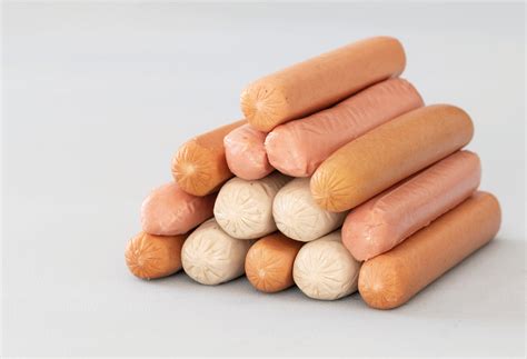Imagen de salchichas vienesas cocinándose en un sartén hasta dorarse.
