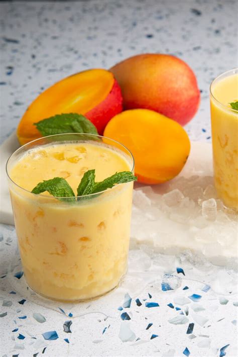 Vaso de lassi de mango servido, decorado con menta fresca.