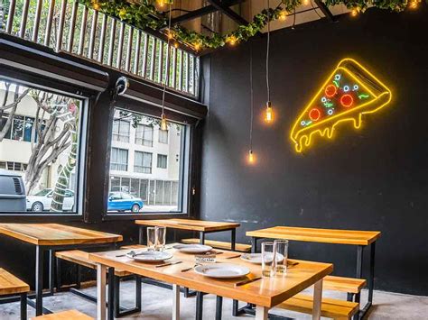 Interior de un local moderno de pizzería con decoración cuidada.