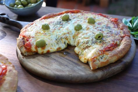 Plano detallado de una pizza al molde de estilo argentino con jamón y morrón.