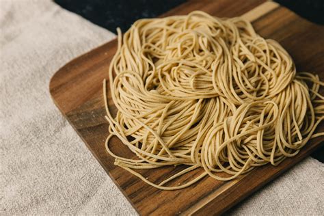 Esquema visual comparativo: Ramen tradicional con fideos de trigo frente a versión adaptada con fideos de arroz y otros ingredientes sin gluten.