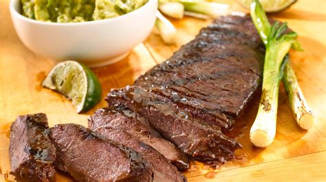 Fotografía gastronómica de un plato de carne de res al ajillo con láminas de ajo dorado y perejil fresco