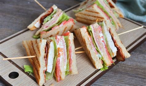 club sándwich de tres pisos cortado en cuartos y sujetado con palillos