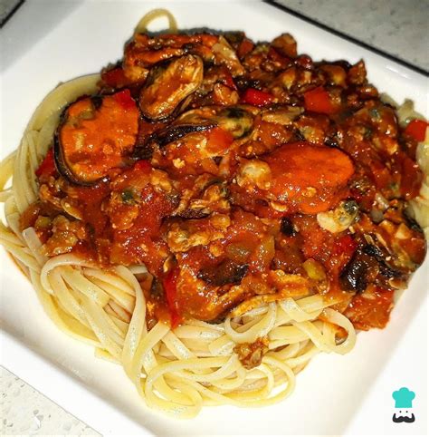Plato de pasta con mariscos variados y salsa roja