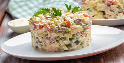 Molde de ensalada rusa compactada en un recipiente.