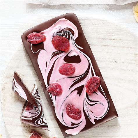 tableta de chocolate negro con trozos de frambuesa y fresa sobre un fondo oscuro