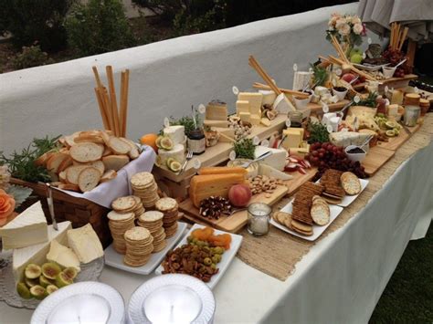 Mesa de quesos y embutidos con frutas, panes y dips