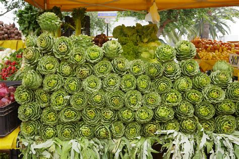 Foto de alcachofas frescas en un mercado con un fondo desenfocado de verduras