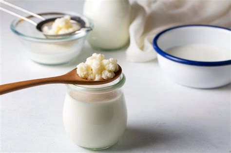Un vaso de kéfir de leche casero y granos de kéfir