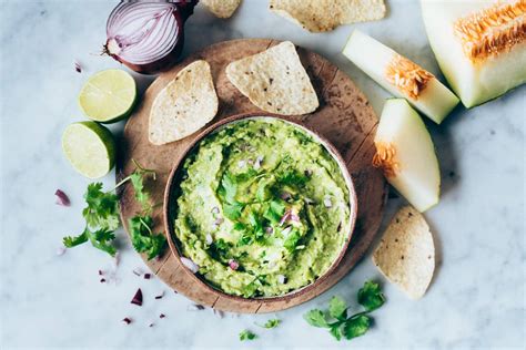 Tabla con distintos tipos de dips y untables vegetarianos: hummus, guacamole, paté de remolacha, con crudités y pan
