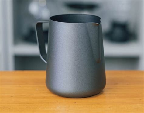Equipo esencial para la creación de Latte Art, incluyendo jarra, punzón y termómetro