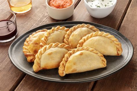 variedad de empanadas horneadas y fritas en una mesa para compartir