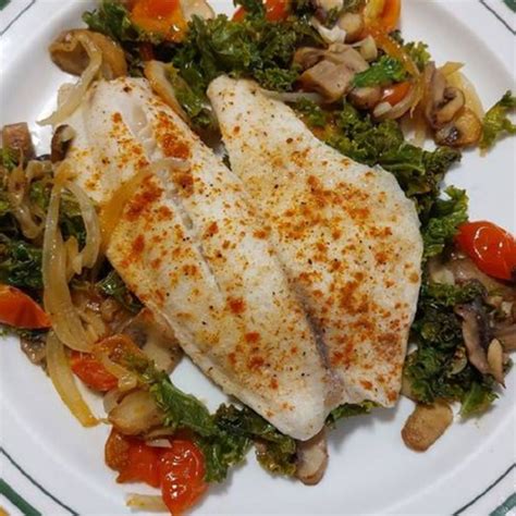 Fotografía de un plato de tilapia al horno con pimientos y otras verduras.