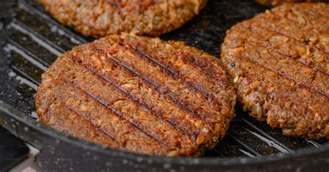 Hamburguesas de cerdo cocinándose en una plancha caliente