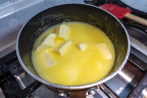 Primer plano de la mantequilla derritiéndose en una cazuela con ajo.