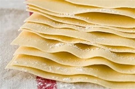 Láminas de lasaña secas en un paquete y salsa de tomate casera