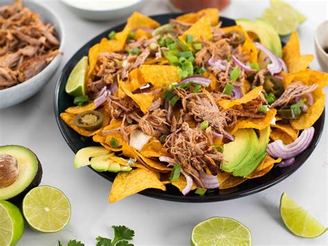 Foto de un dip de arroz con pulled pork y salsa BBQ servido con chips de tortilla