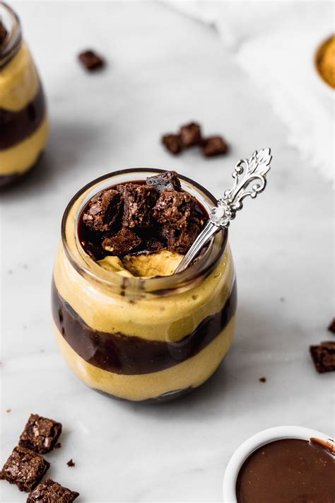 Mousse de lúcuma con salsa de chocolate y brownies, vista de cerca con textura cremosa y capas