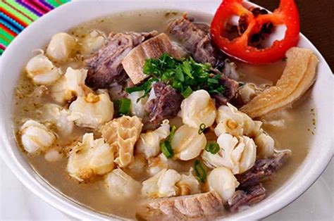 Sopa de mote humeante con carnes y hierbas