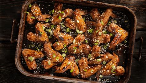 Brochetas de alitas de pollo teriyaki con jengibre sobre una bandeja de horno