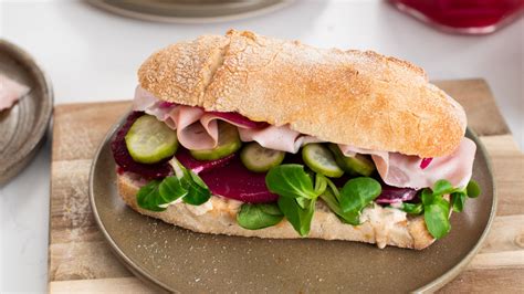 Sándwich vegetariano fresco y colorido con marraqueta en plato blanco