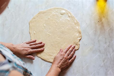 Manos amasando una masa de pizza elástica