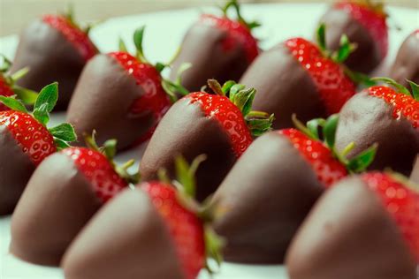 Plato con frutillas frescas cubiertas de chocolate y algunas con decoraciones variadas.