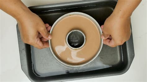 Molde de rosca con flan de chocolate horneándose a baño maría