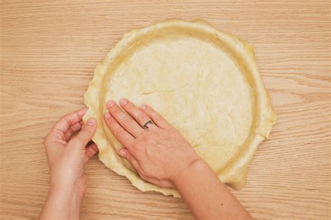 Fotografía de una masa de tarta estirada sobre papel vegetal lista para el molde