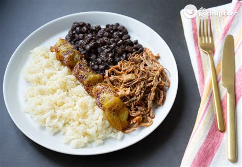 Plato de pabellón criollo tradicional con arroz, carne mechada, caraotas negras y tajadas de plátano