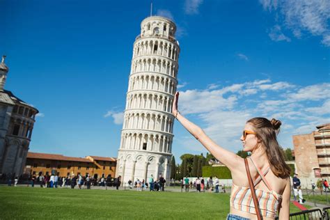 Fotografía de la icónica Torre de Pisa con una persona disfrutando de un helado artesanal frente a ella.