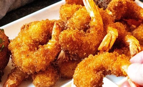 Tabla comparativa mostrando el contenido nutricional de camarones apanados fritos vs. horneados por cada 100 gramos.