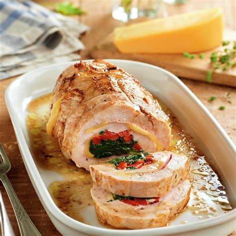 Pechuga de pavo rellena horneándose en una fuente de horno con vegetales